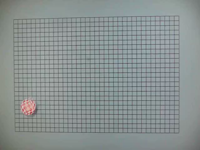 Monitor displaying a ball with red and white squares pattern spinning and bouncing on a grey background with a grid.