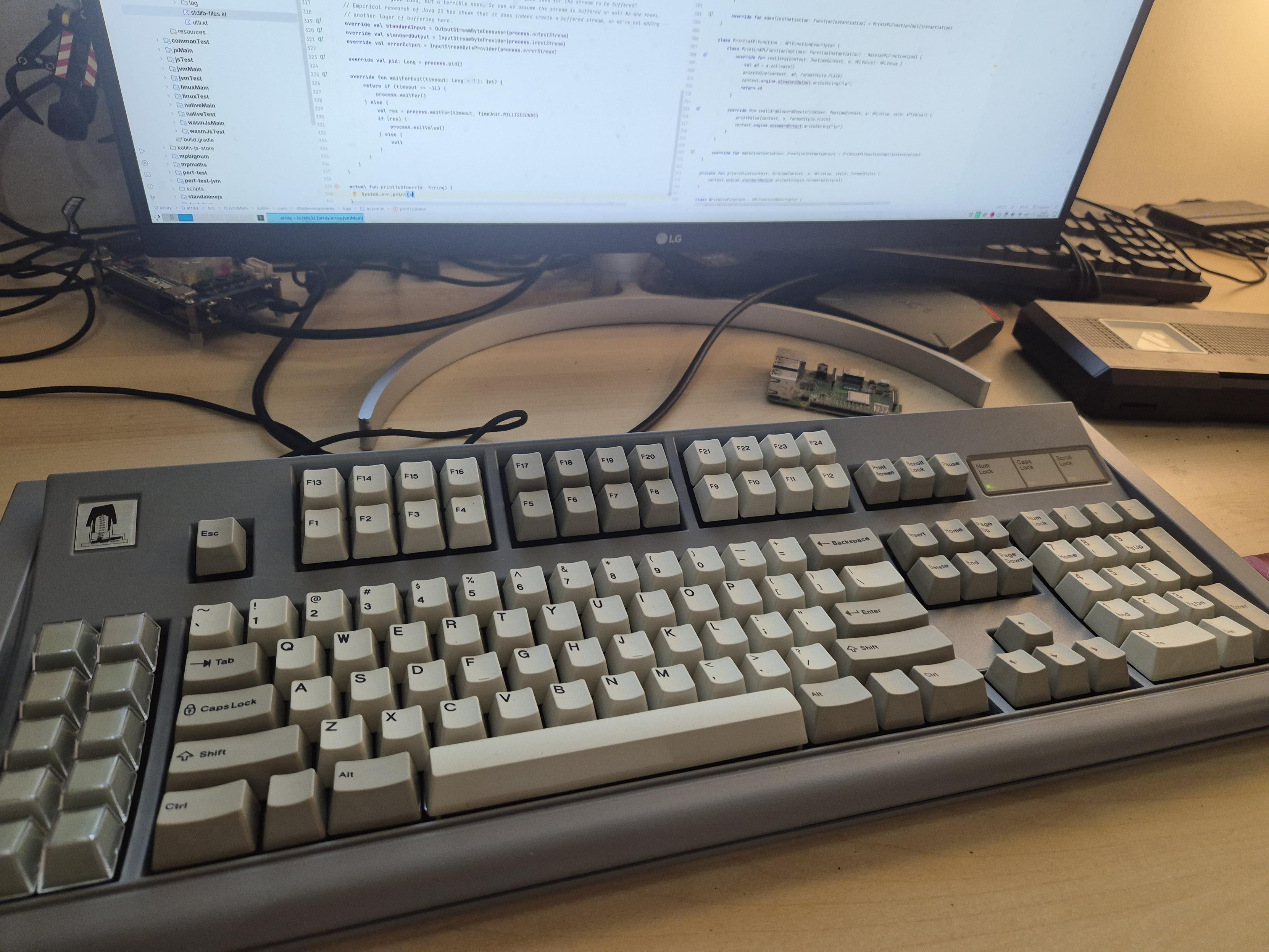 Photo of an F122 keyboard in front of a monitor running a development tool