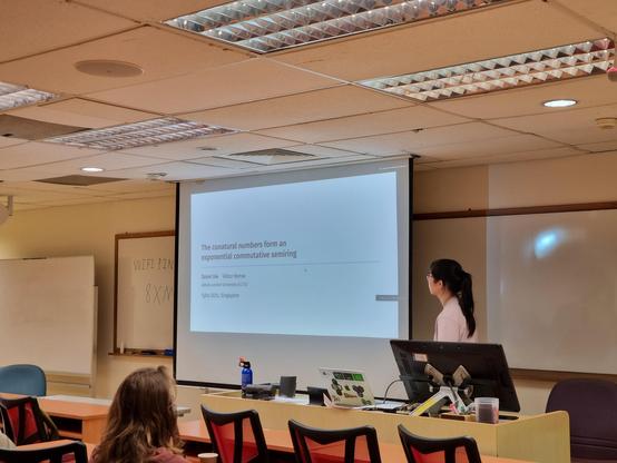 Szumi Xie presenting "The conatural numbers form an exponential commutative semiring". First slide + speaker.